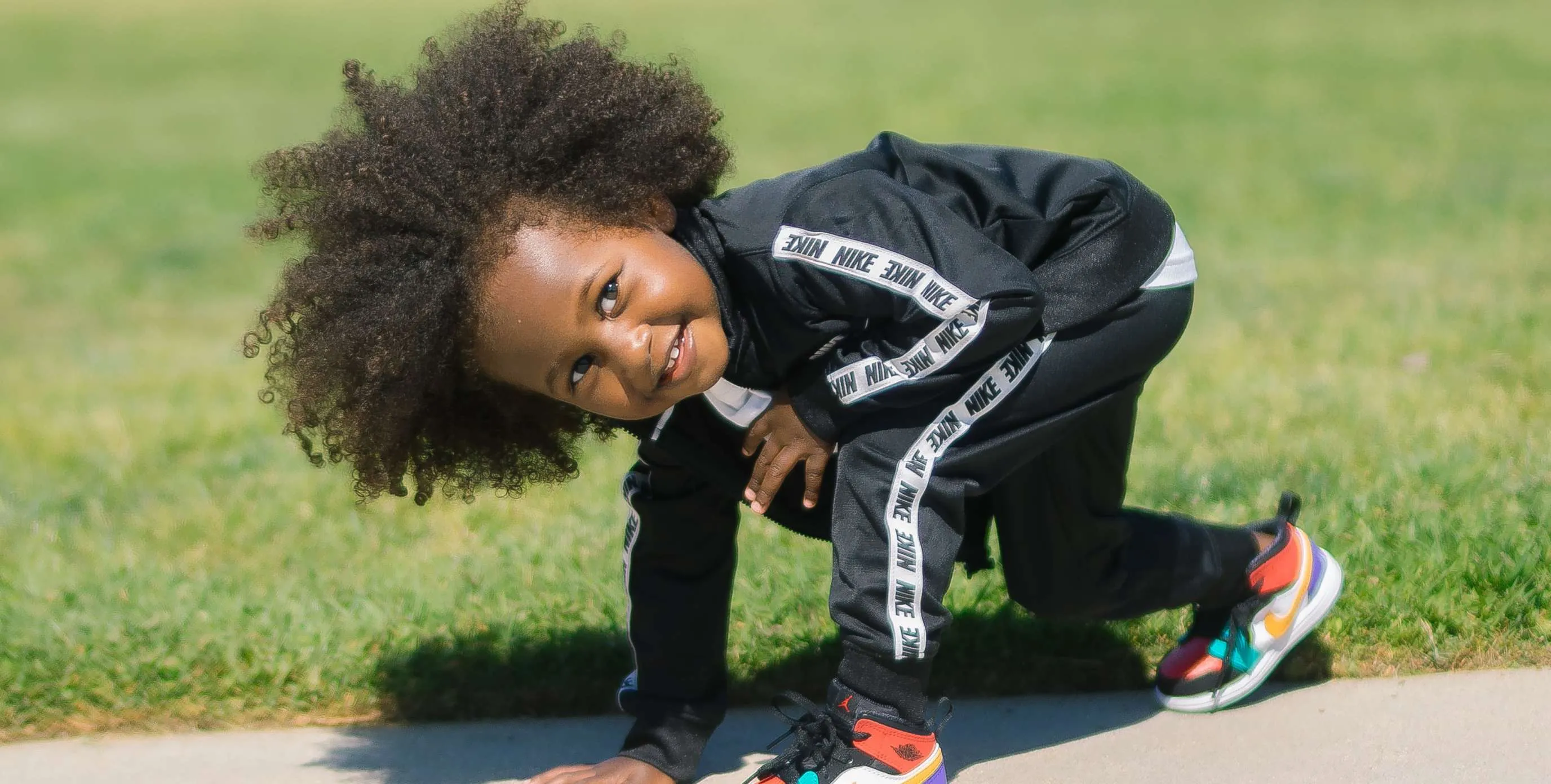 Ein kleiner Junge im Trainingsanzug macht sich bereit zum Laufen