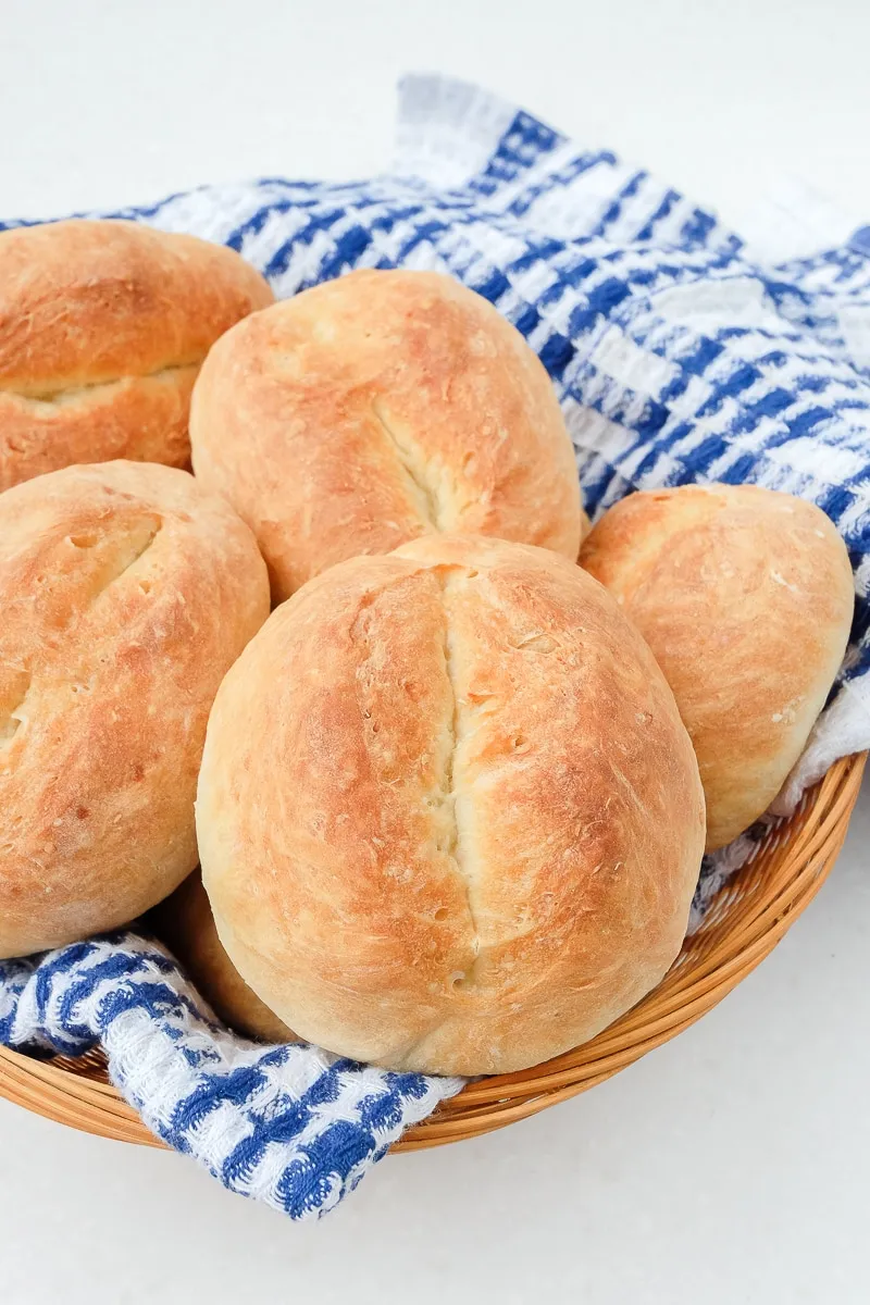 Ein Korb mit deutschen Brötchen auf einem blauen Tuch