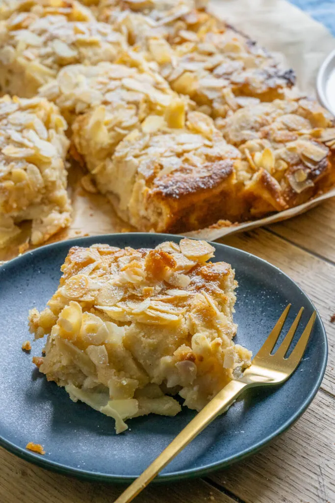 Ein köstlicher Apfelkuchen mit Marzipan vom Blech, perfekt für die Herbst- und Winterzeit, mit goldbrauner Kruste und Puderzucker bestäubt