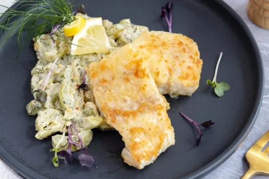 Ein köstliches Tellergericht mit gebratenem Kabeljau und traditionellen deutschen Schmorgurken als Beilage.
