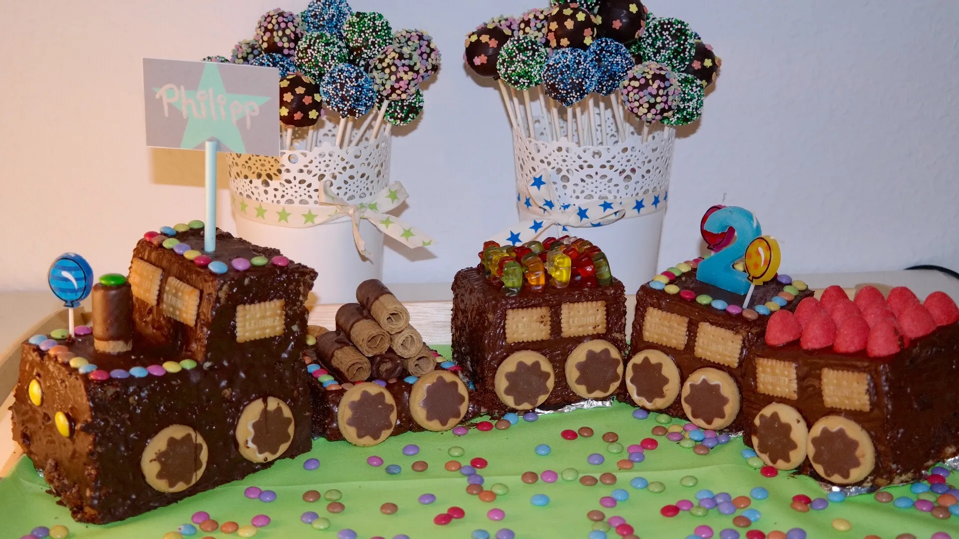 Ein kunstvoll verzierter Eisenbahn-Kuchen aus Marmorkuchenstücken, bereit für die Kinderparty