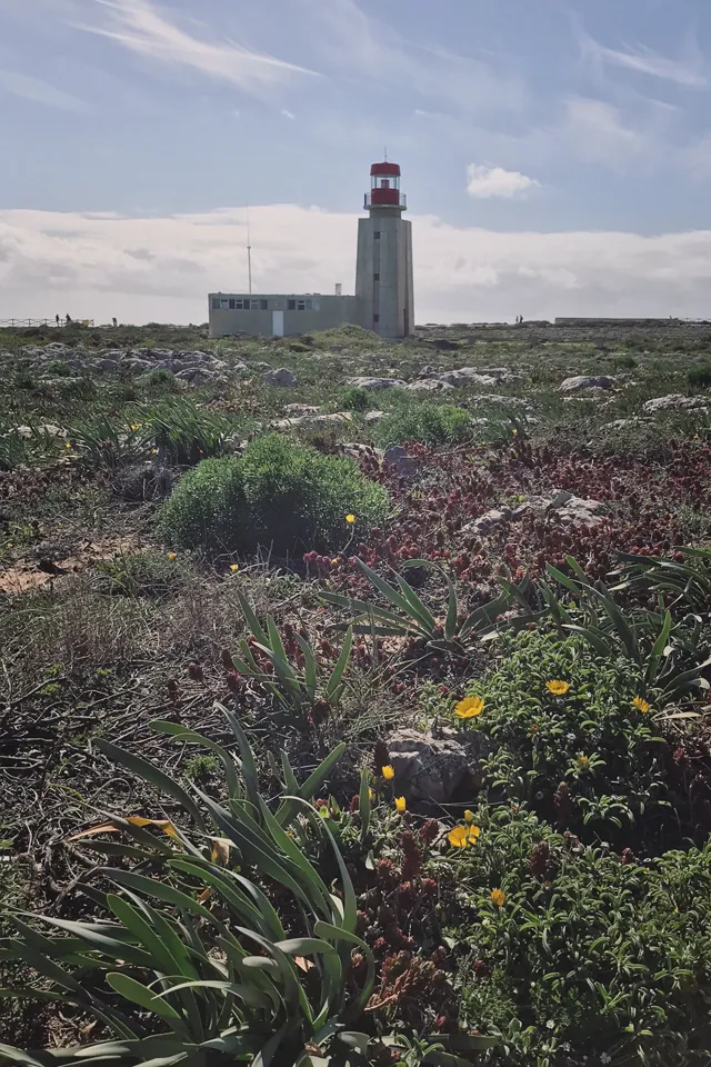 Ein Leuchtturm auf einer felsigen Klippe mit Blick auf das weite Meer unter einem blauen Himmel