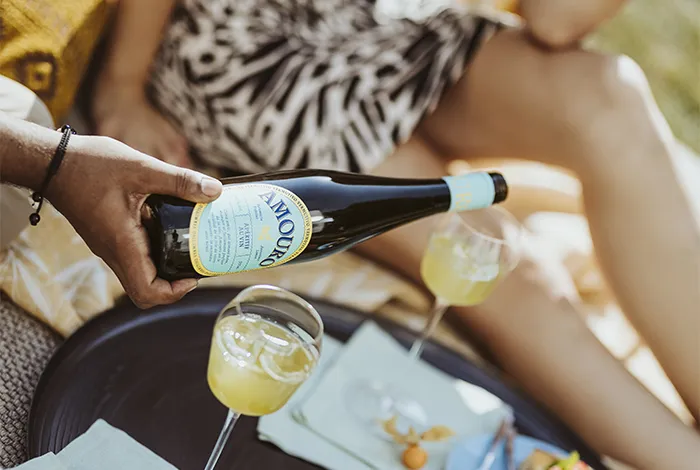 Ein Mann hält eine Flasche Amouro Vermutivo in der Hand