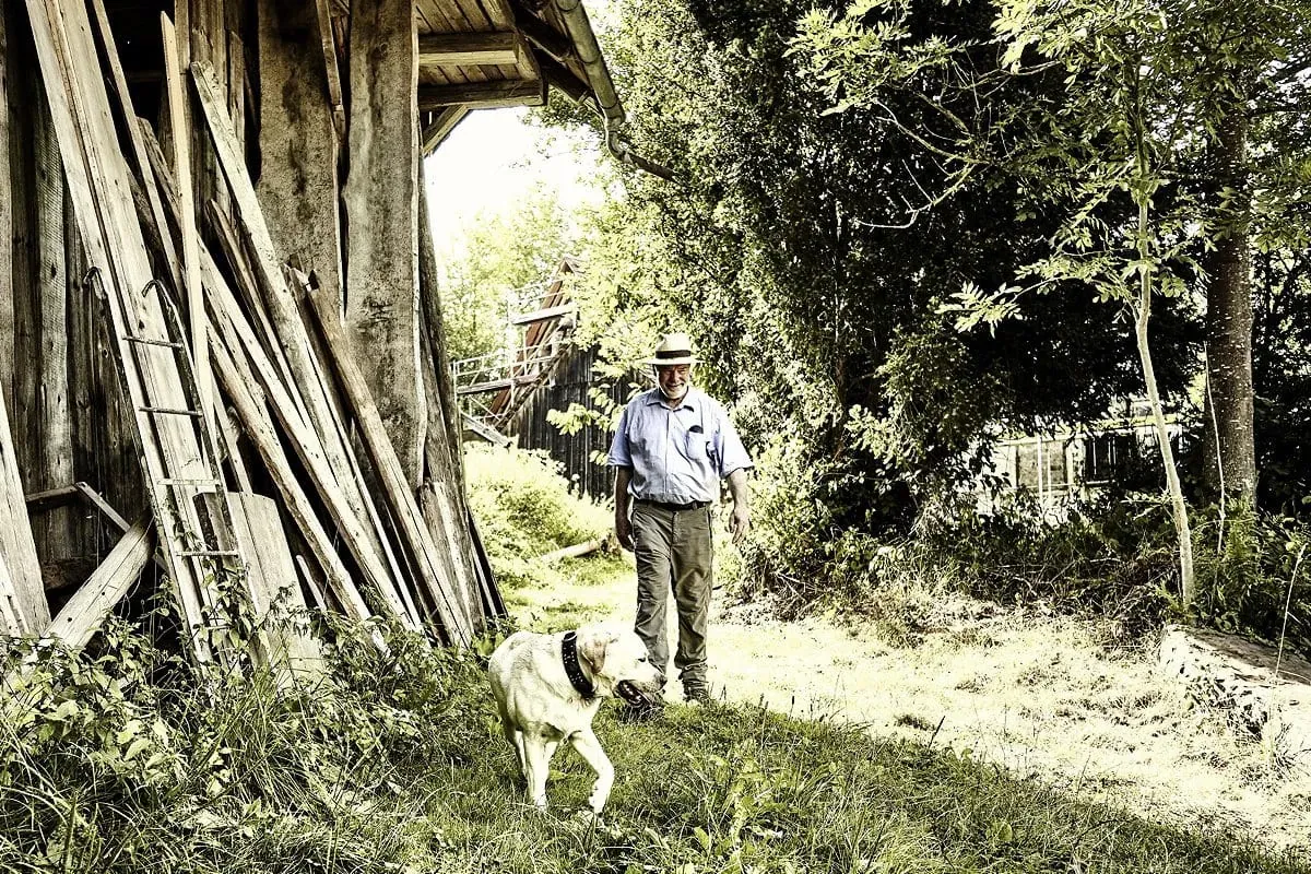 Ein Mann mit seinem Hund erkundet die idyllische Natur rund um das Hotel Kronelamm, ein hervorragendes Hotel mit Hund in Baden-Württemberg.