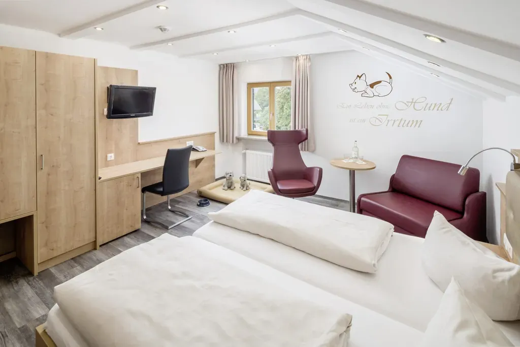 Ein modern eingerichtetes Doppelzimmer mit einem gemütlichen Hundebett im Hundesporthotel Wolf in Oberammergau, das den Komfort für alle Gäste gewährleistet.