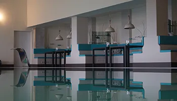 Ein modernes Hallenbad mit klarem, blauen Wasser und warmem Licht, ideal für Entspannung und Sport