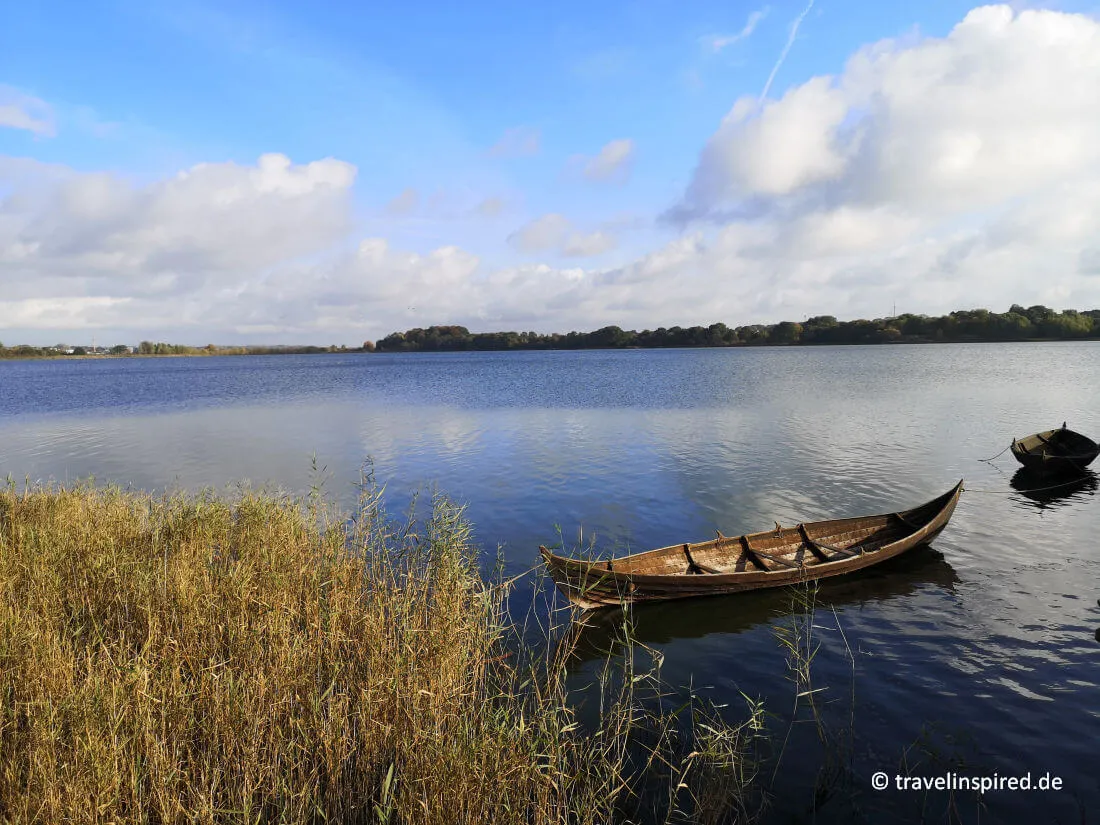 Ein nachgebautes Wikingerboot am Haddebyer Noor im Wikinger Museum Haithabu, eine Reise in die Geschichte bei Unternehmungen in Norddeutschland.