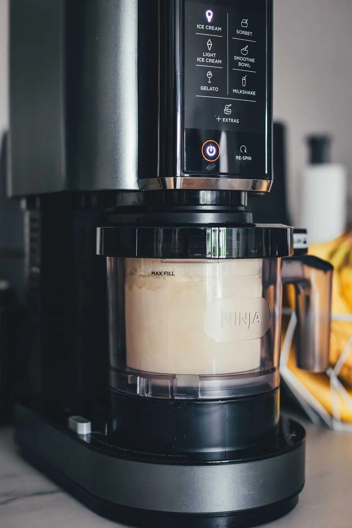 Ein Ninja Creami Gerät in Aktion, das die gefrorene Vanilleeismasse zu perfekter Cremigkeit verarbeitet.