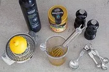 Ein Olivenöl-Zitronen-Honig-Dressing wird in einer Schüssel angerührt, um die Lachsfilets vor dem Backen zu marinieren und zu würzen.