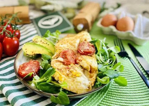 Ein reichhaltiges Protein-Omelett mit frischen Kräutern und Beilagen auf einem Teller