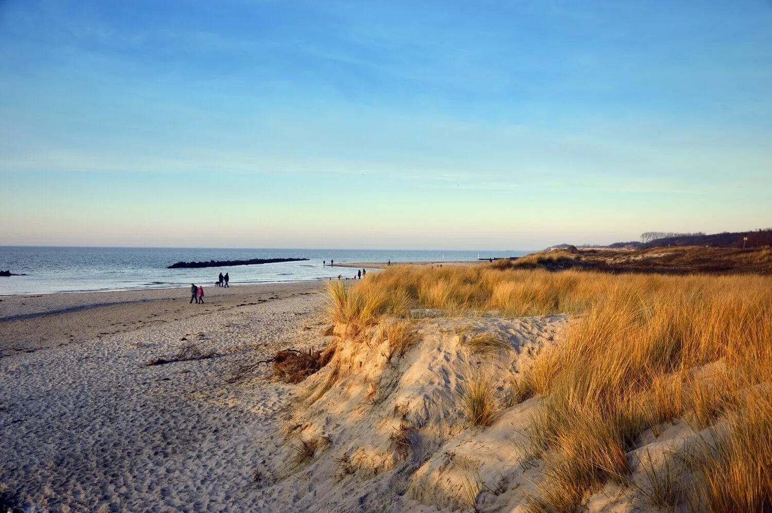 Ein rotes Kajak gleitet ruhig über das glitzernde Wasser der Ostsee bei Sonnenuntergang