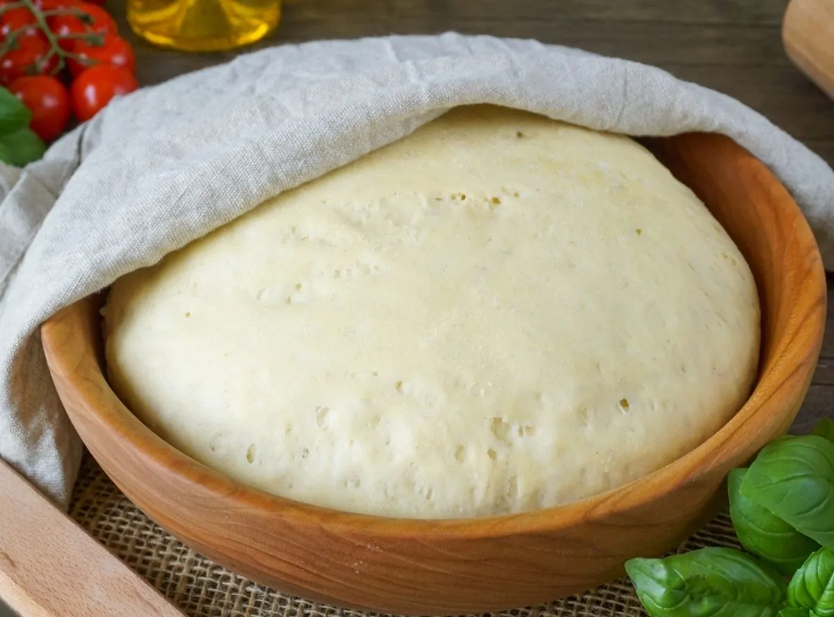 Ein runder, frischer Pizzateig, bereit für den Belag.