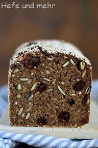 Ein runder, kaffeefarbener Laib schwedisches Kaffeebrot, garniert mit ganzen Kaffeebohnen und einem Zweig.