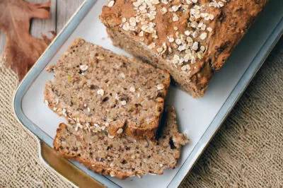 Ein rustikal gebackenes Dinkel-Vollkornbrot, außen goldbraun und knusprig, innen weich und saftig, mit sichtbaren Körnern und Samen.