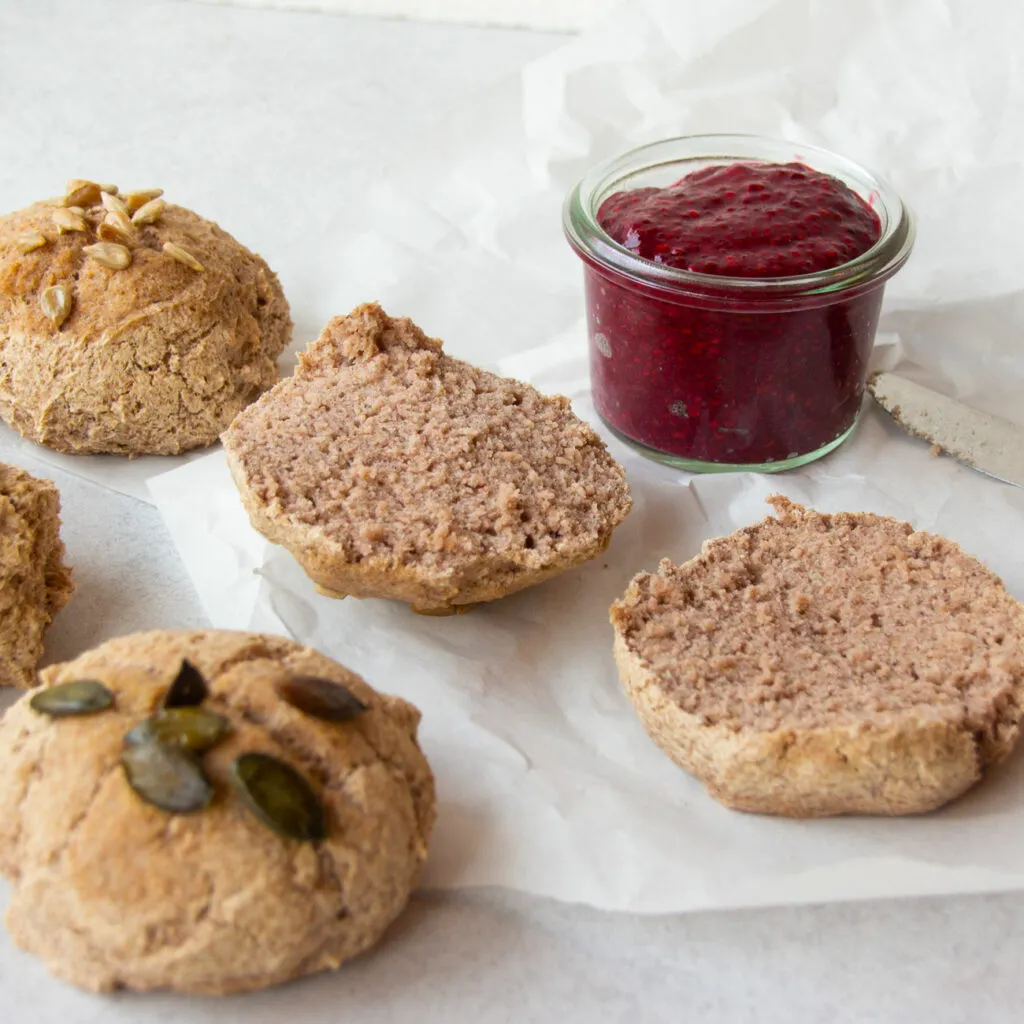 Ein rustikaler Korb mit verschiedenen Buchweizenbrötchen, teils mit Saaten bestreut.