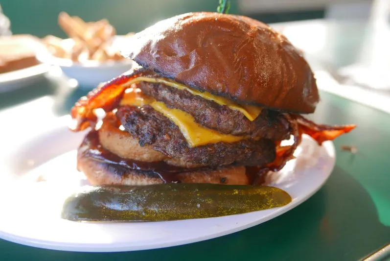 Ein saftiger Burger aus einem amerikanischen Diner, der die Neugier auf die deftigen Spezialitäten der deutschen Esskultur weckt.