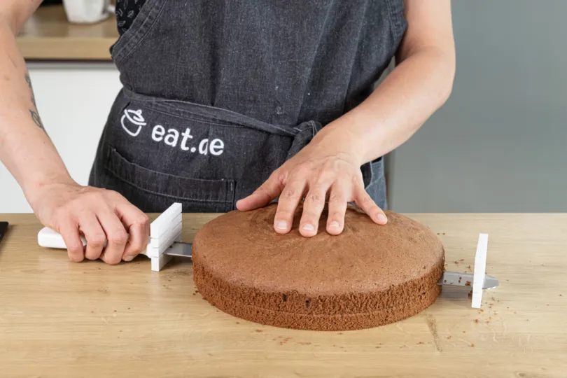 Ein Schokobiskuit wird in drei Böden geteilt