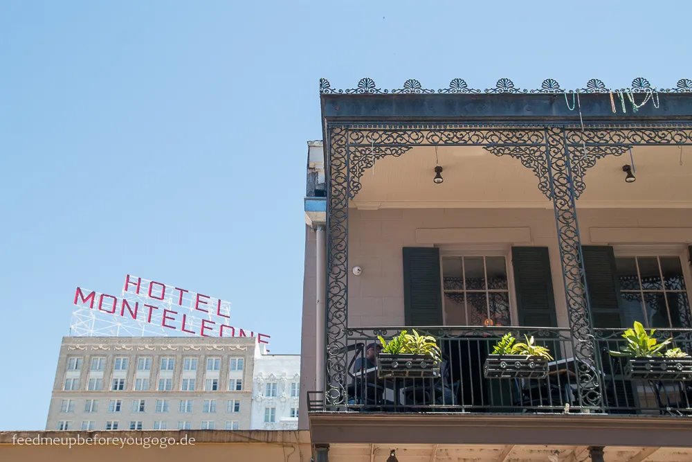 Ein schöner Balkon im French Quarter, verziert mit schmiedeeisernen Geländern und Pflanzen, typisch für die Architektur von New Orleans.