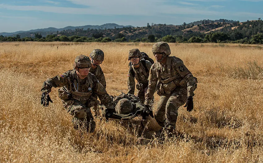 Ein Soldat trägt zwei Kettlebells, was die funktionelle Anwendung der Fitnessübungen zeigt.