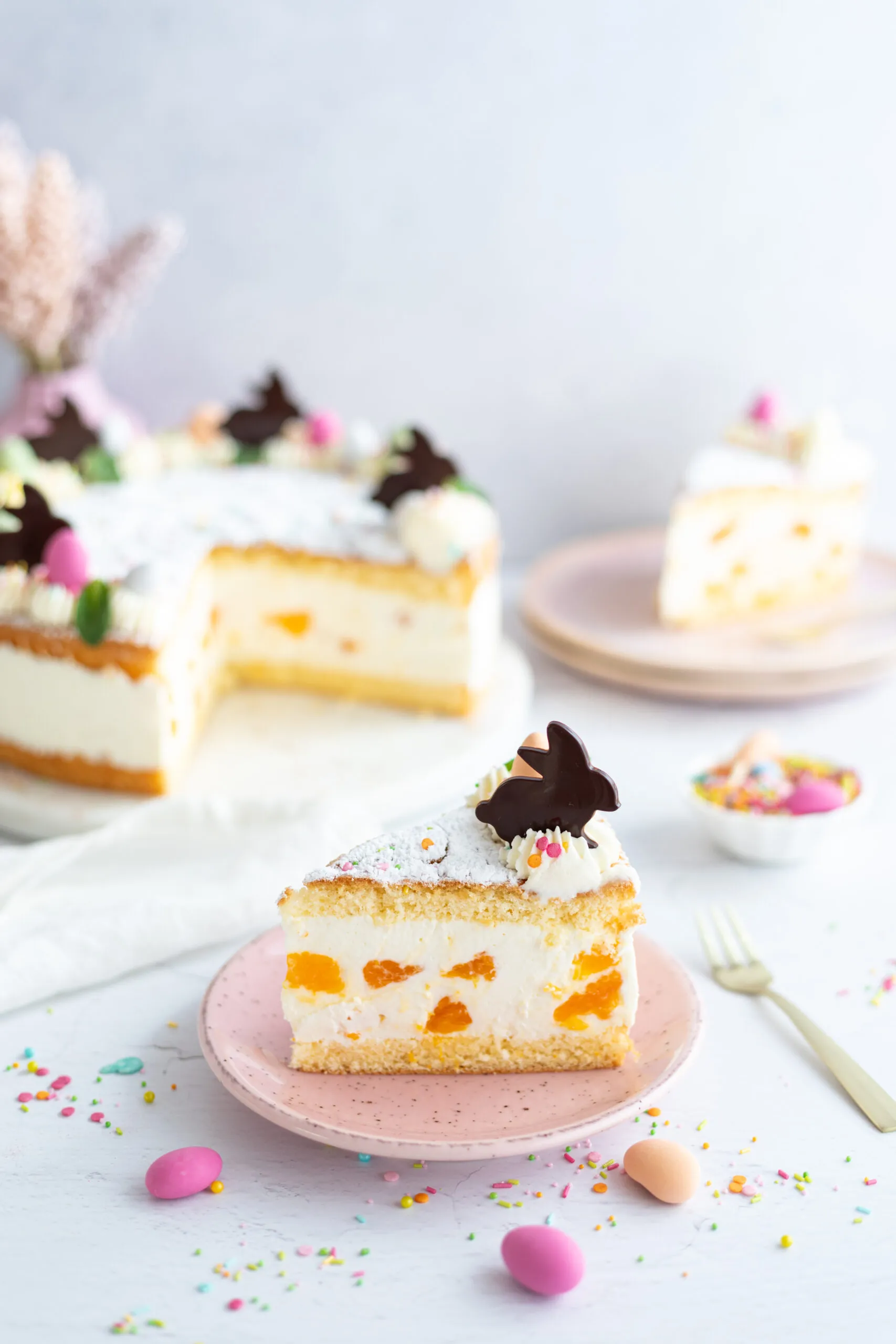 Ein Stück cremige Käsesahnetorte mit Mandarinen auf einem Teller, bereit zum Genießen