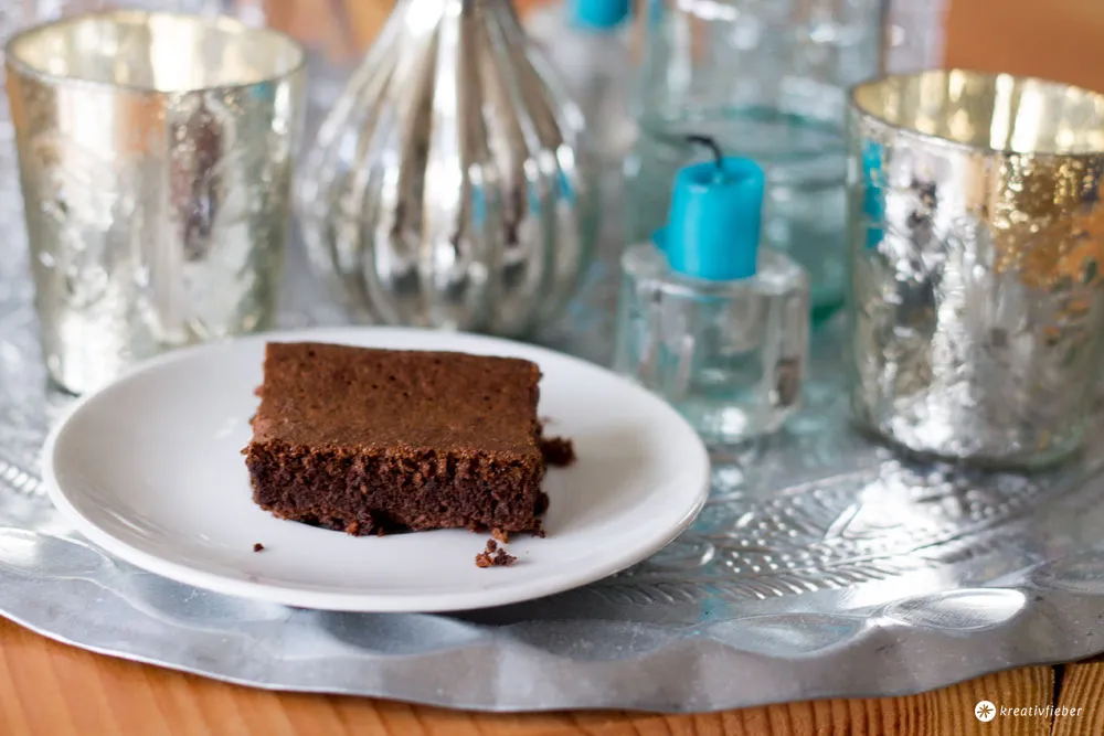 Ein Stück Nutella Kuchen mit drei Zutaten auf einem Teller und Besteck, fertig zum Genießen