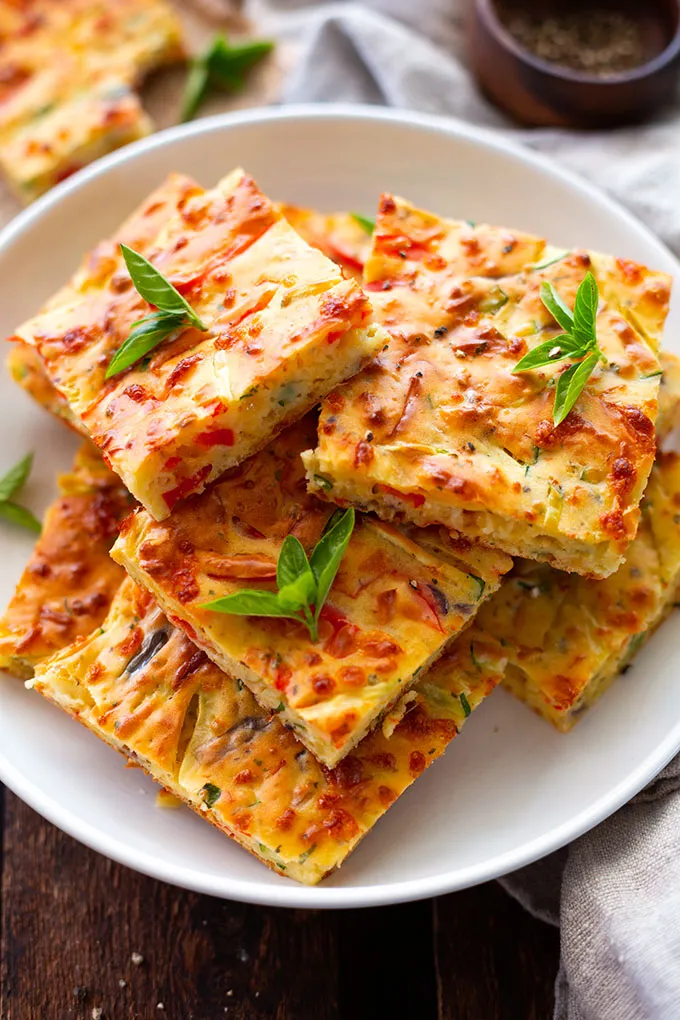 Ein Stück vegetarische Gemüse-Quiche auf einem Teller, perfekt zum Mitnehmen oder für eine schnelle Mahlzeit