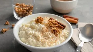 Ein Teller Milchreis mit Zimt und Zucker, dekoriert mit frischen Beeren.