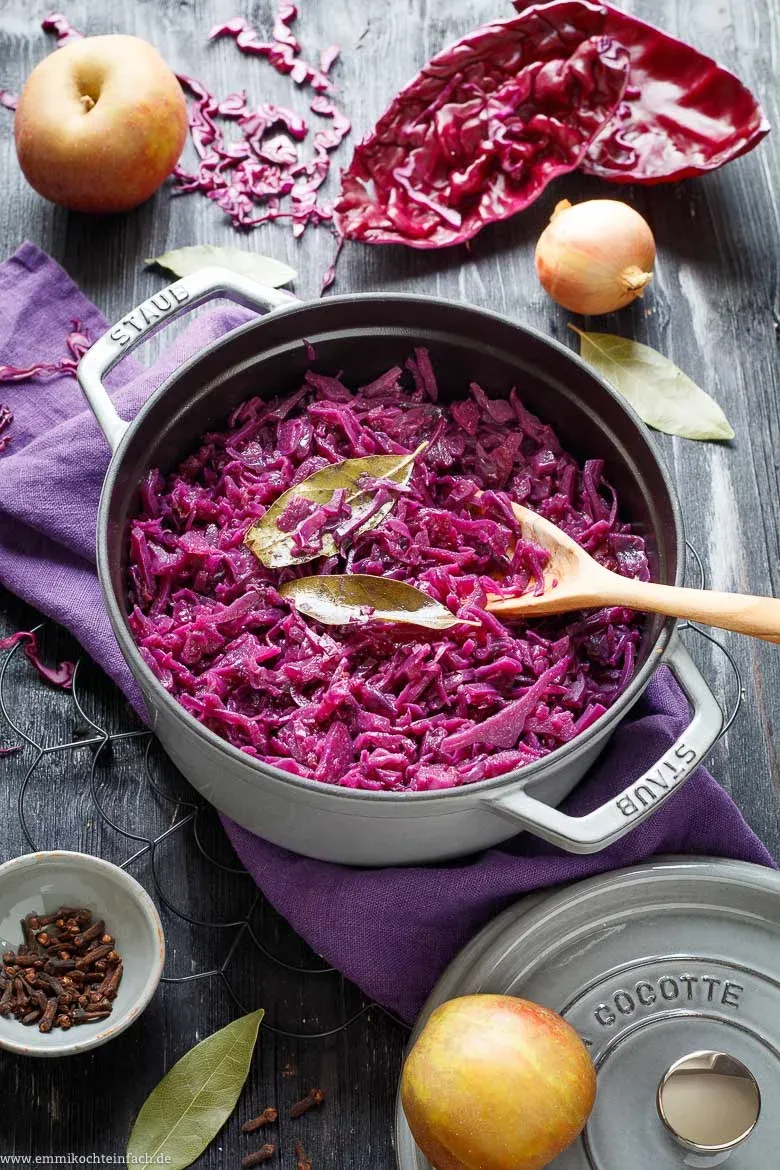 Ein Teller mit dampfendem Rotkraut, serviert neben Knödeln und Braten.