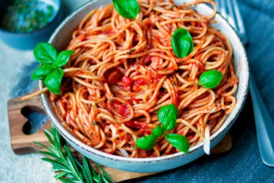 Ein Teller Spaghetti mit hausgemachter Tomatensoße und frischem Basilikum, appetitlich angerichtet