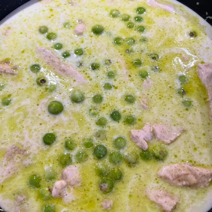 Ein Topf mit köchelndem Grünen Thai Curry, in dem Huhn und Gemüse garen