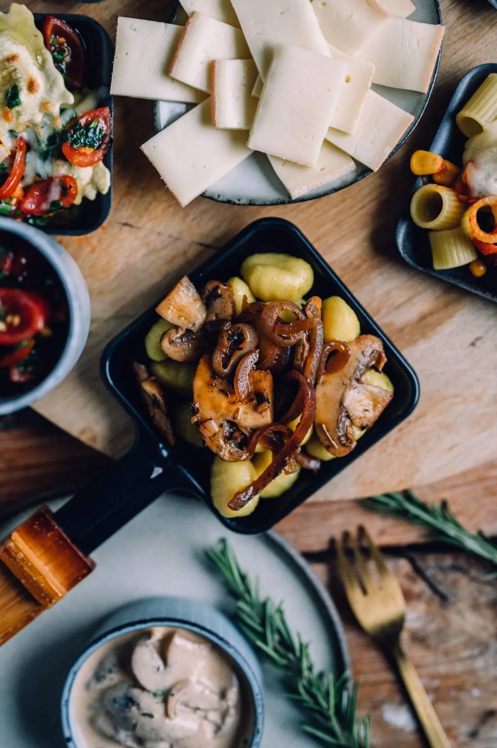 Ein vegetarisches Raclette-Pfännchen reich gefüllt mit Gemüse und würziger Sauce