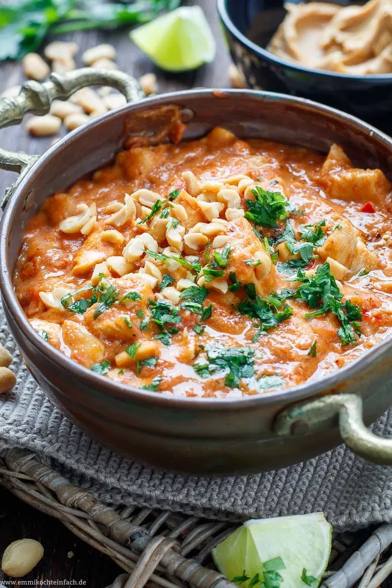 Ein weiterer Blick auf den Erdnuss-Hähnchen-Topf, angereichert mit frischen Kräutern und Erdnüssen, der die Vielfalt und den Geschmack authentischer afrikanischer Rezepte repräsentiert.