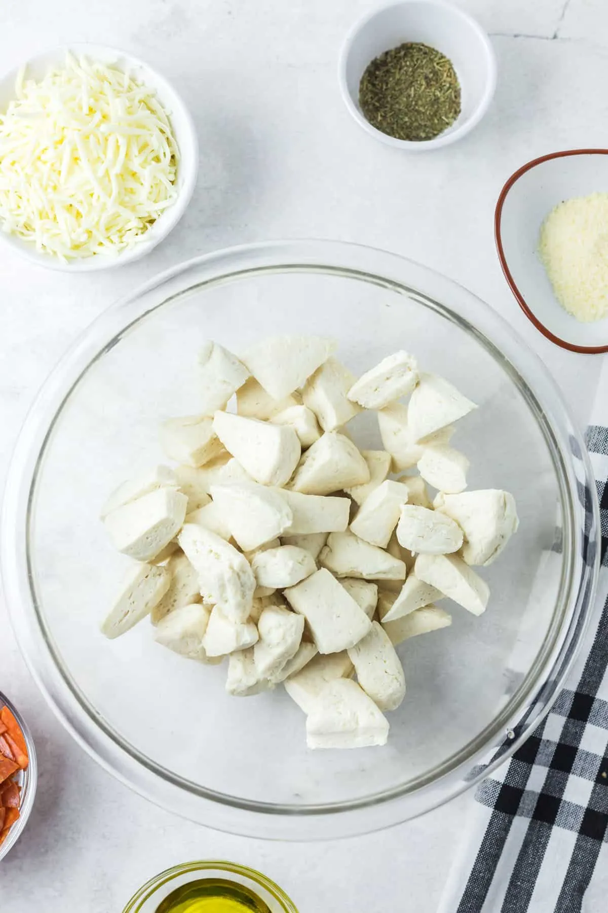 Ein-Zoll-Stücke von Keksteig in einer Glasschüssel.