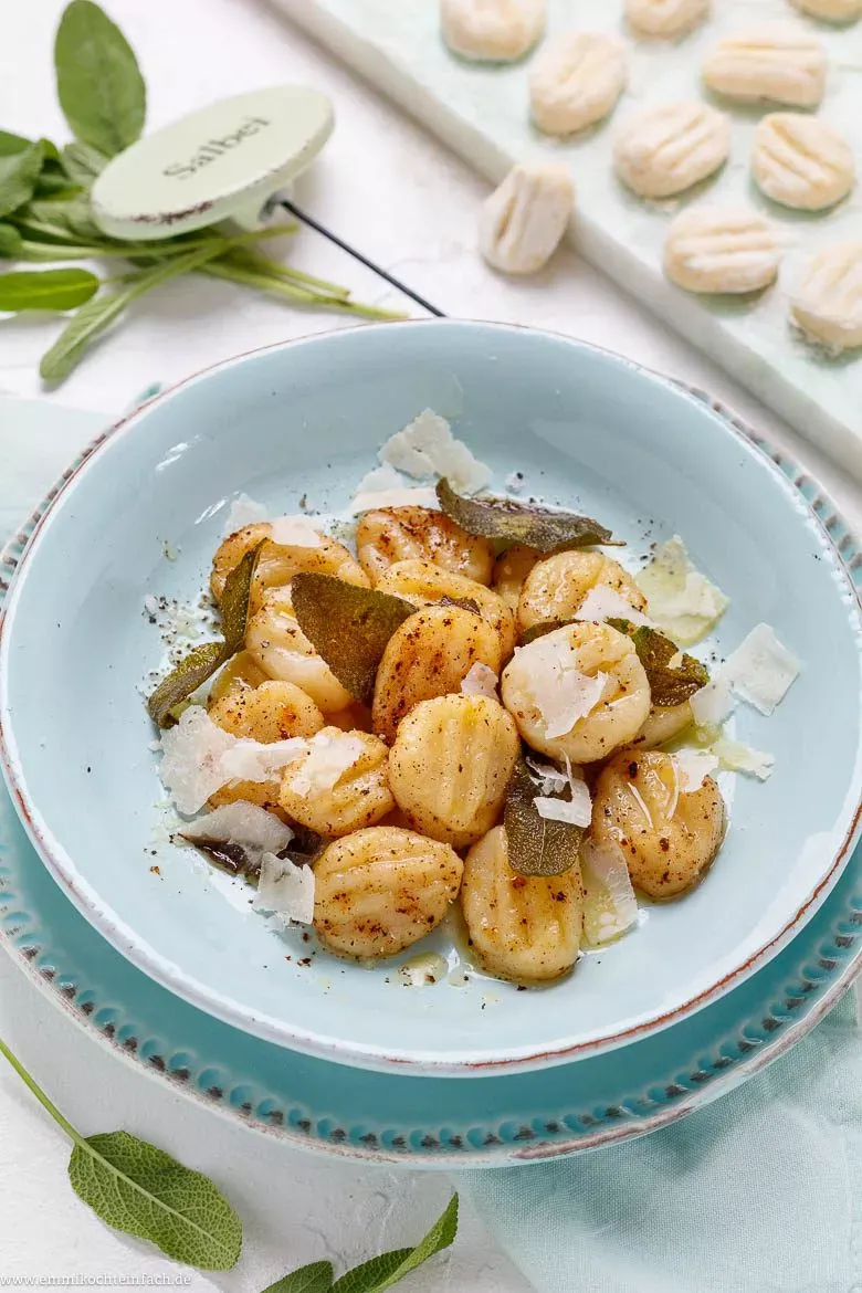 Eine Auswahl an Gnocchi-Gerichten, darunter Gnocchi mit Salbeibutter, Tomatensoße und Pesto. Die Vielfalt der Gerichte soll die Vielseitigkeit von Gnocchi demonstrieren und die Nutzer zu eigenen Kreationen inspirieren.