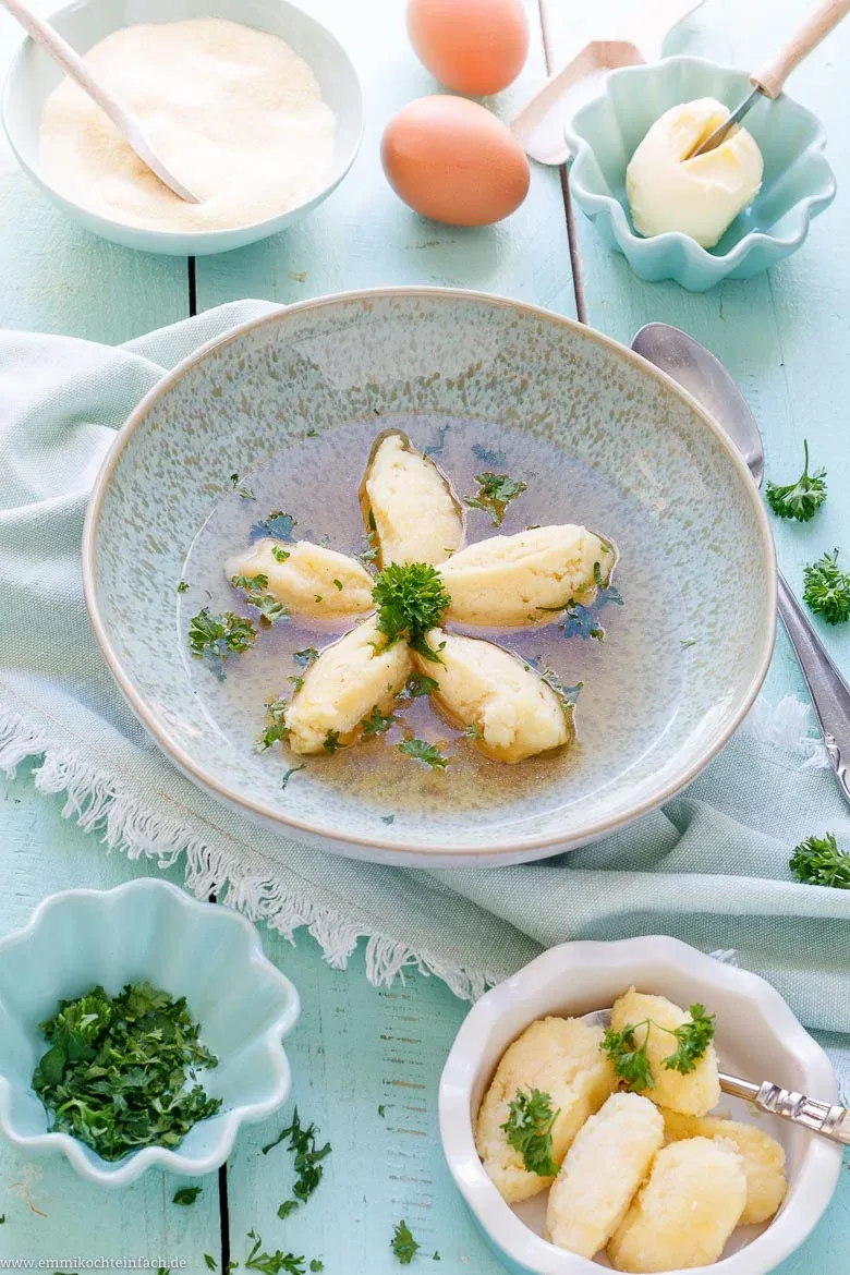 Eine dampfende Schale klassische Grießklößchensuppe mit frischer Petersilie, bereit zum Genießen.