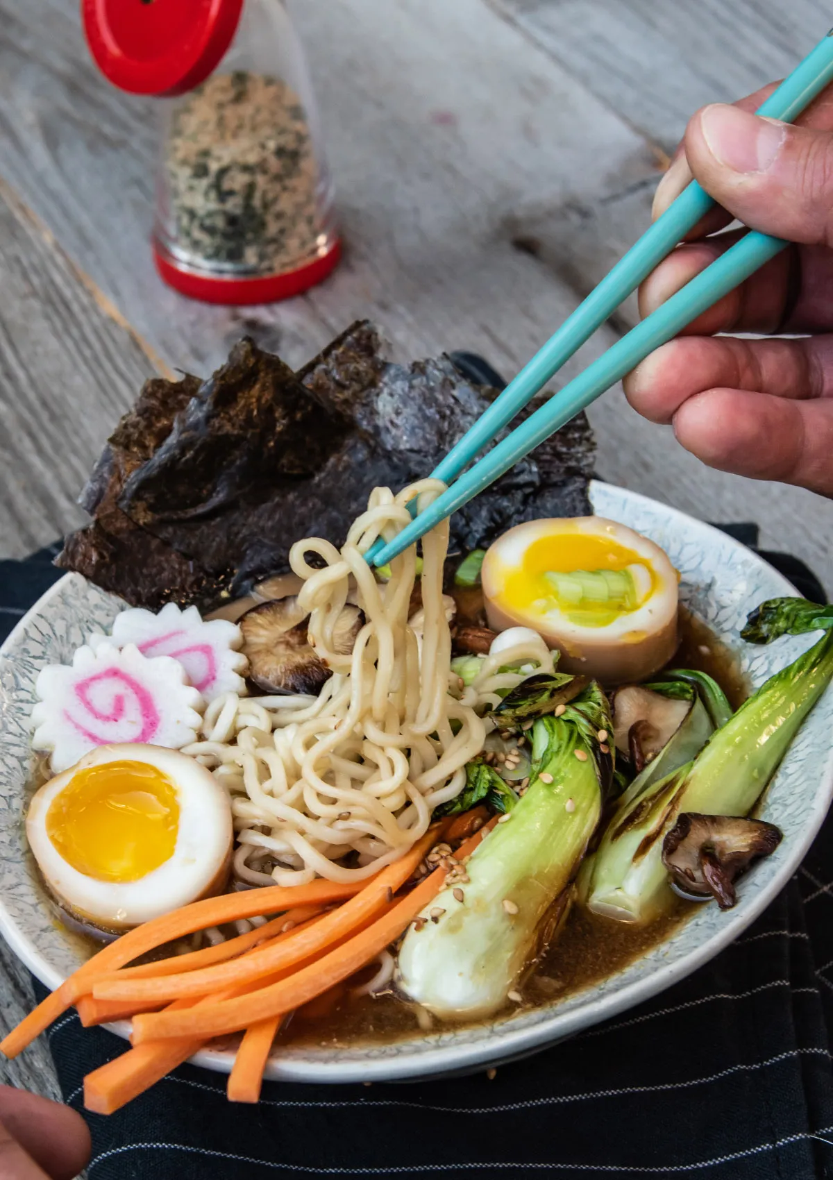 Eine dampfende Schale schnelles Ramen Suppen Rezept mit Nudeln, Ei, Gemüse und Frühlingszwiebeln, bereit zum Genießen.