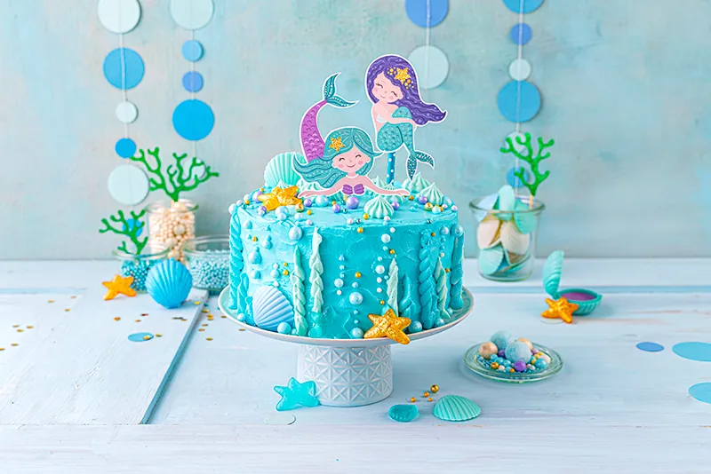 Eine detailreiche Ansicht der fertigen Meerjungfrauen Torte mit glänzenden Dekorperlen, ein Highlight für jeden Kindergeburtstag.