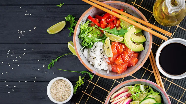 Eine farbenfrohe Poke-Bowl mit Lachs, Avocado, Paprika und Rucola