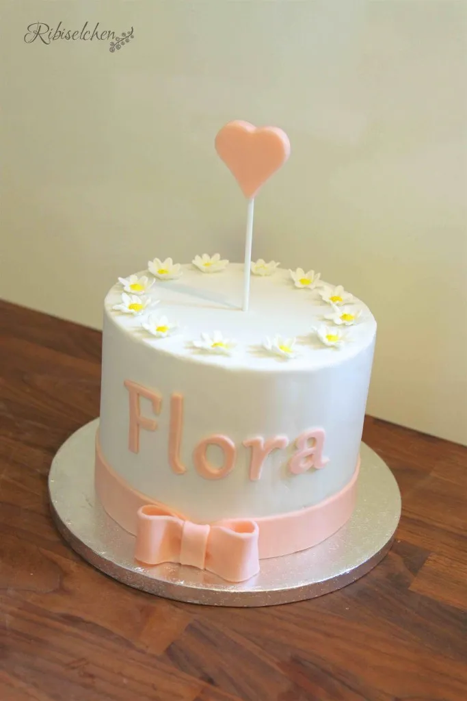 Eine festliche Babyparty-Torte in Rosa mit dem Namen "Flora" aus Modellierschokolade