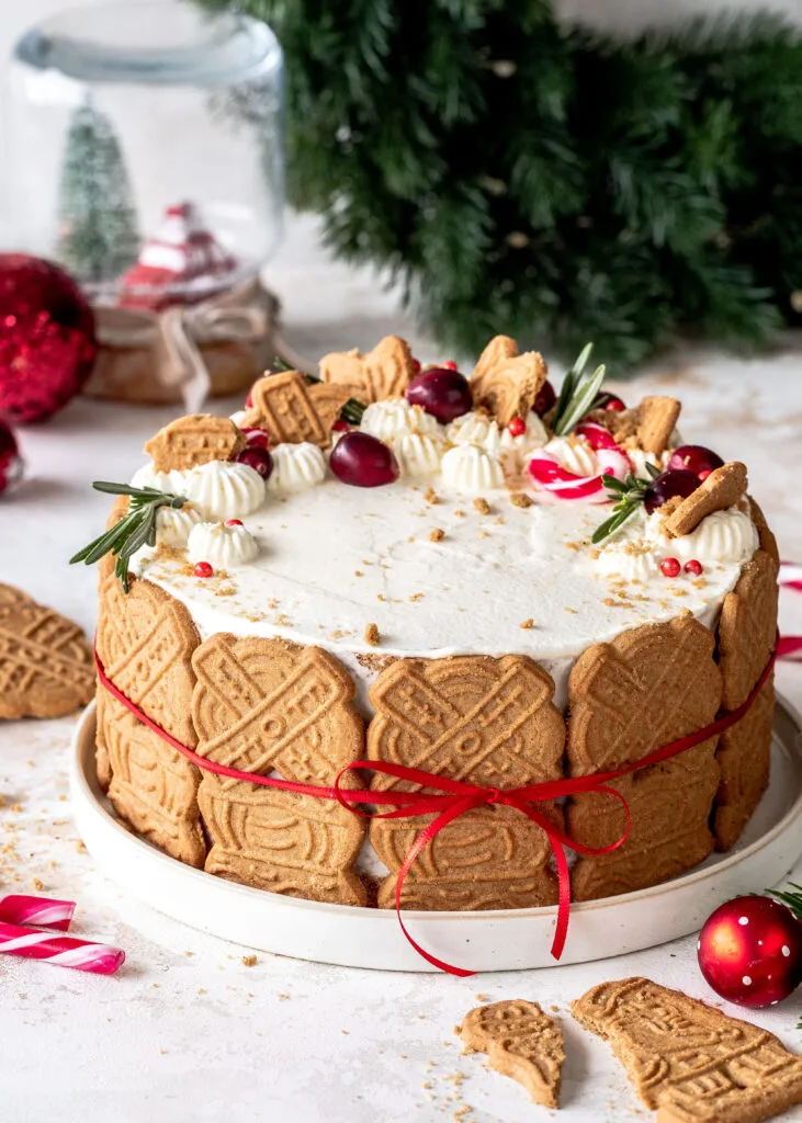 Eine festliche Bratapfel-Spekulatius-Torte mit Sahnetupfen und Spekulatiuskeksen am Rand, perfekt für die Weihnachtszeit.