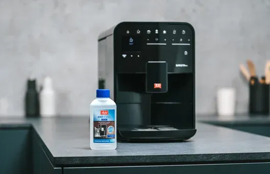 Eine Frau reinigt sorgfältig die abnehmbaren Teile der Melitta Barista SE Kaffeevollautomatenbrühgruppe.