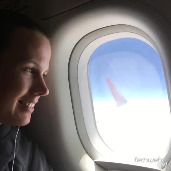 Eine Frau steht am Strand und genießt die Aussicht auf das Meer
