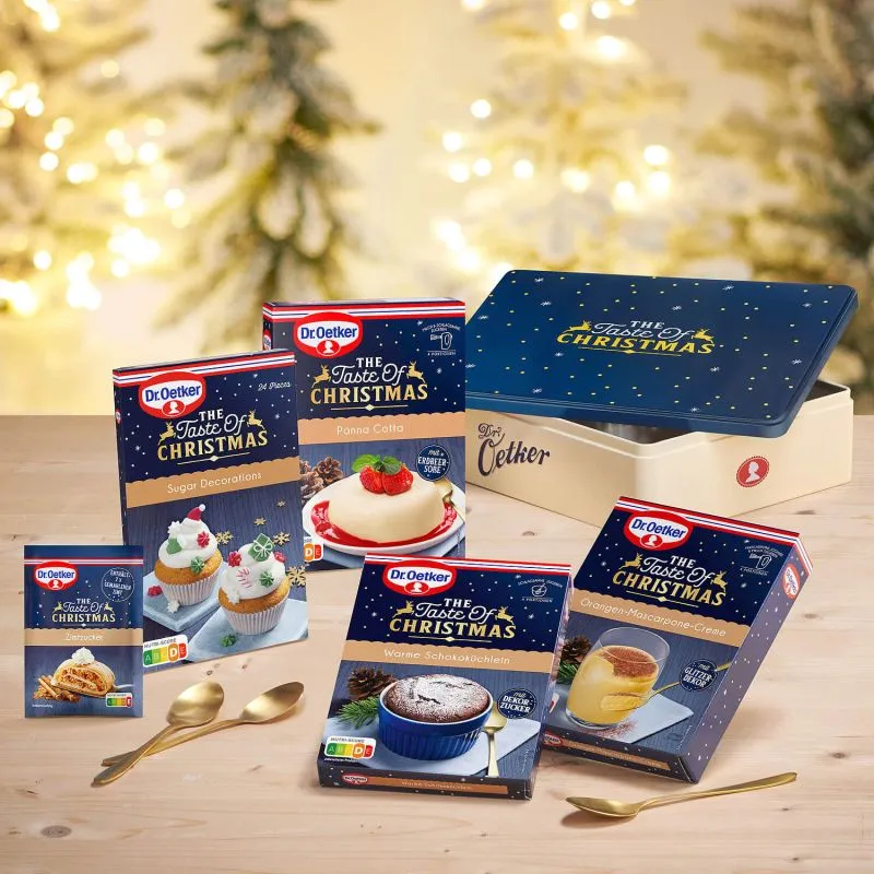 Eine gefüllte Aufbewahrungsdose mit weihnachtlichen Backzutaten oder Dessertpulvern, präsentiert vor einem festlichen Hintergrund