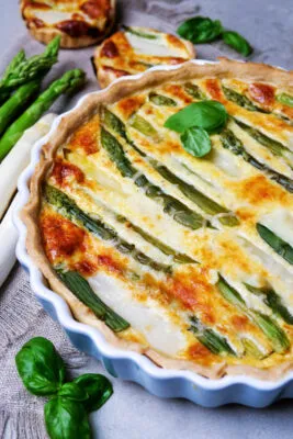 Eine goldbraune Spargel-Quiche, gefüllt mit weißem und grünem Spargel, perfekt als einfaches Hauptgericht.