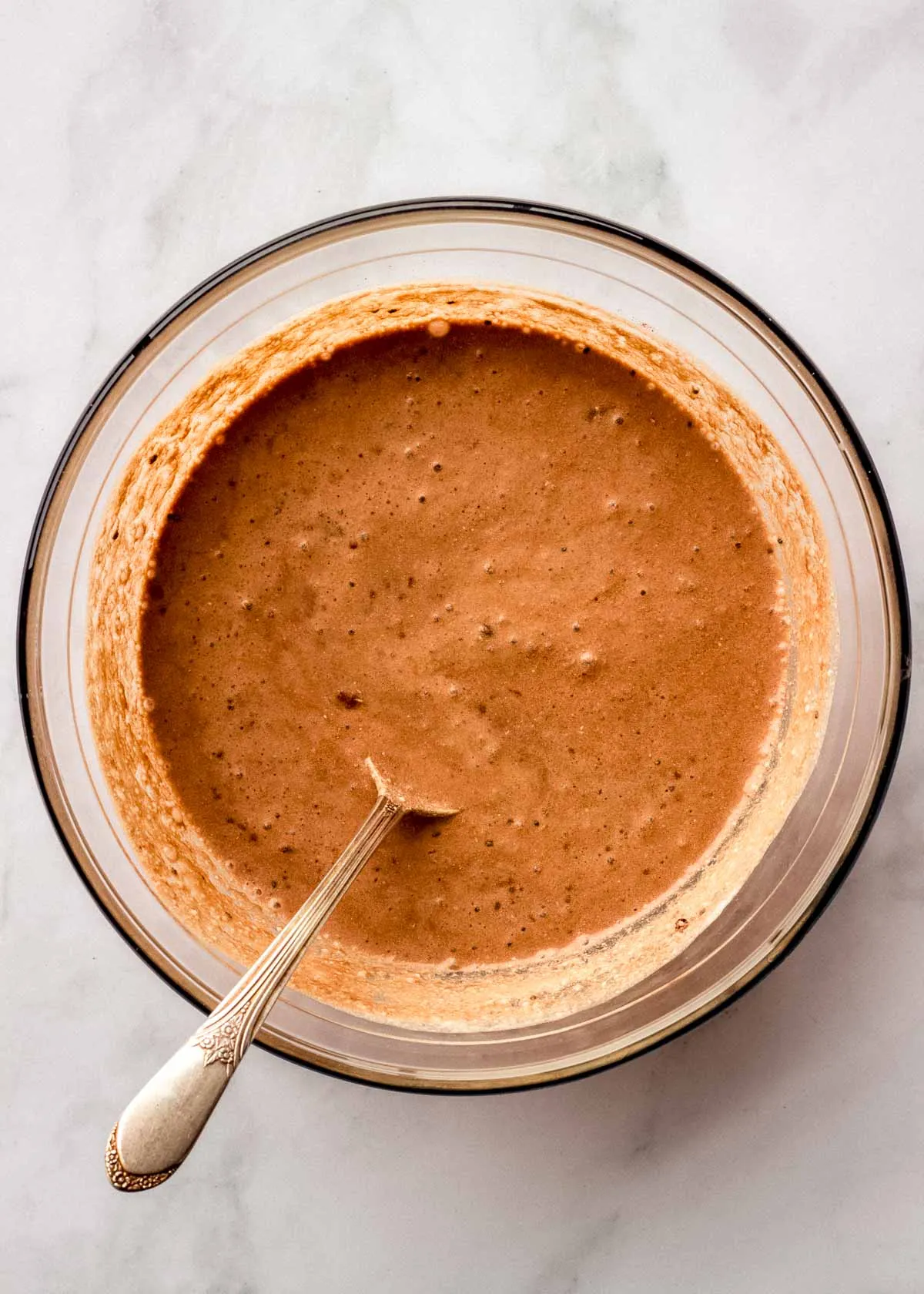 Eine große Glasschüssel mit Tiramisu Overnight Oats Zutaten nach dem Mischen.