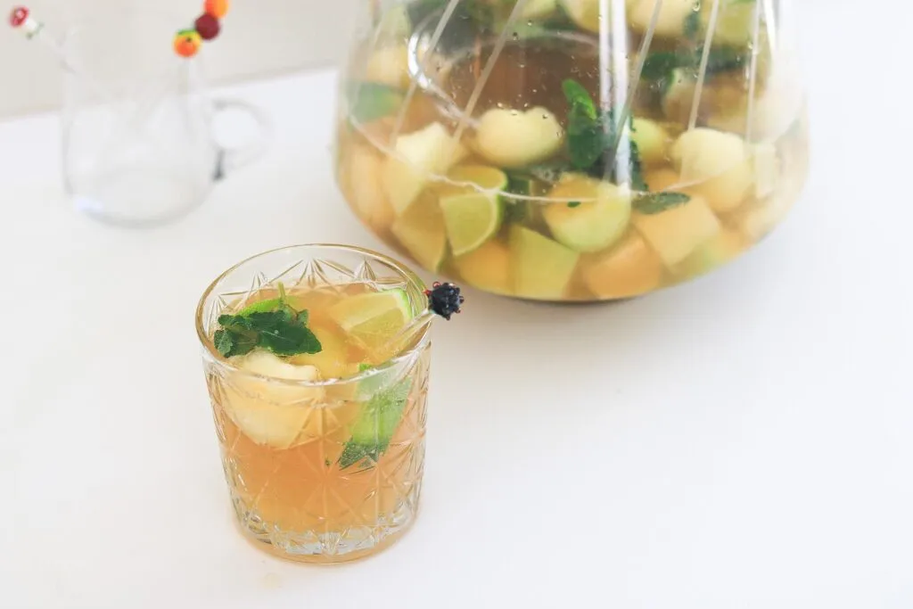 Eine große Schale mit Caipirinha Bowle alkoholfrei, gefüllt mit Limettenscheiben und Eiswürfeln