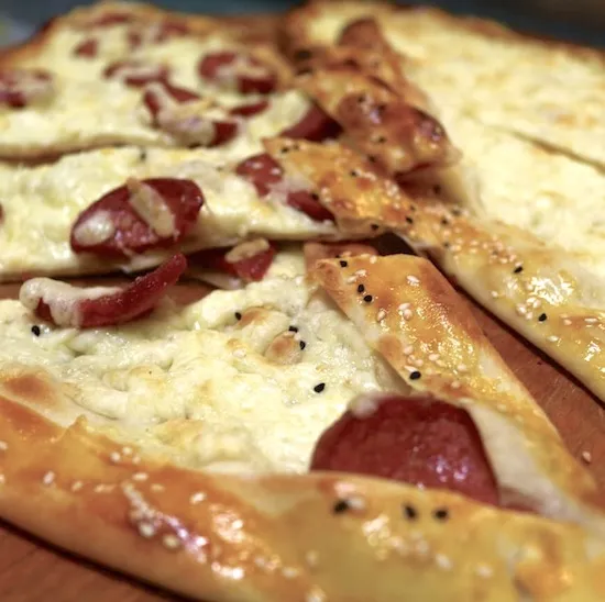 Eine großzügig belegte Pide mit Käse und Wurst, frisch aus dem Steinofen der Bäckerei Halil Ibrahim