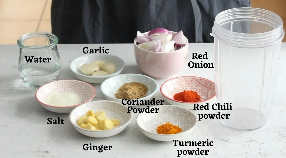 Eine Handvoll roter Zwiebeln auf einem Holzbrett, bereit zur Verarbeitung für die Currypaste.