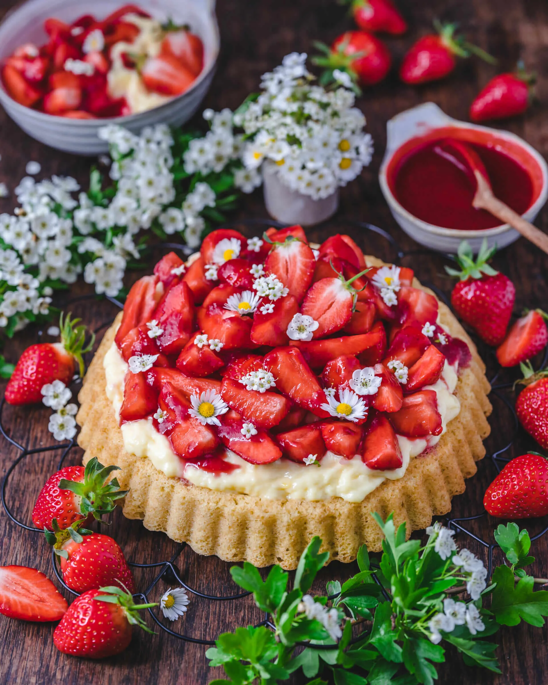 Eine köstliche, frisch zubereitete Erdbeer Pudding Sahne Torte mit glänzendem Erdbeerguss und vielen roten Erdbeeren, bereit für die deutsche Kaffeetafel.