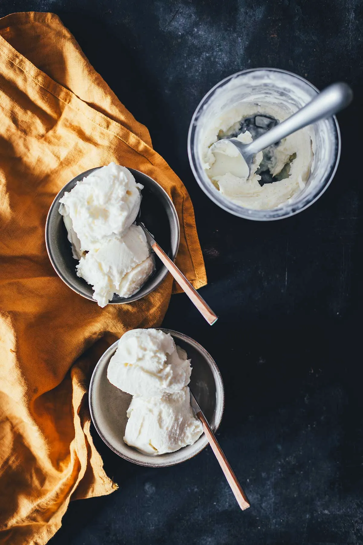Eine Kugel Vanilleeis in einer Schüssel, umgeben von frischen Beeren, bereit für ein leichtes Dessert.
